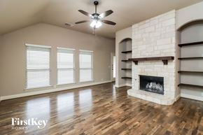 Burleson house for rent - A spacious living room with a fireplace and a ceiling fan.