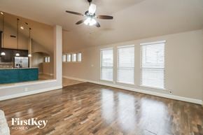 Burleson house for rent - A spacious room with wooden floors and a ceiling fan.