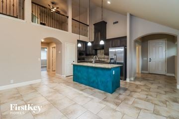 Burleson house for rent - A kitchen with a blue island and a tiled floor.