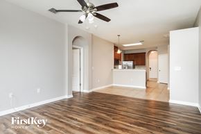 Orlando house for rent - A spacious room with a ceiling fan and wooden flooring.