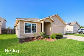 Brookshire house for rent - A beige house with a white garage door and a small window.