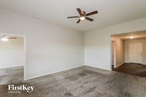 Brookshire house for rent - A spacious room with a ceiling fan and a carpeted floor.