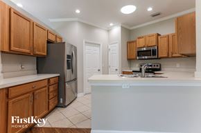Parrish house for rent - a kitchen with wooden cabinets and a white counter top