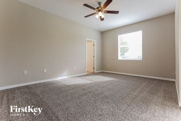 Parrish house for rent - a living room with carpet and a ceiling fan