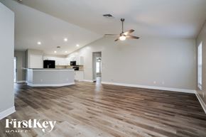 Cape Coral house for rent - A spacious living room with wooden flooring and a ceiling fan.