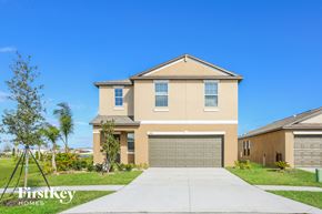 Ruskin house for rent - a house with a garage door and a sidewalk in front of it