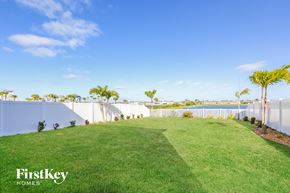 Ruskin house for rent - a backyard with a lawn and palm trees