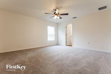 Port Charlotte house for rent - a living room with carpet and a ceiling fan