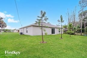 Port Charlotte house for rent - a home with palm trees in the yard and a white house