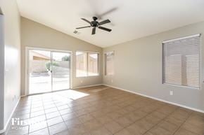 San Tan Valley house for rent - an empty living room with a ceiling fan and a sliding glass door