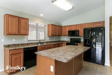San Tan Valley house for rent - a kitchen with black appliances and a granite counter top