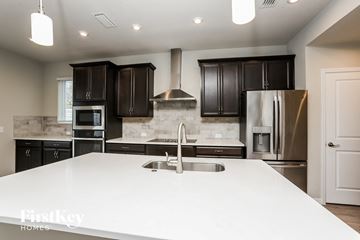 Sanford house for rent - a large white kitchen with black cabinets and stainless steel appliances