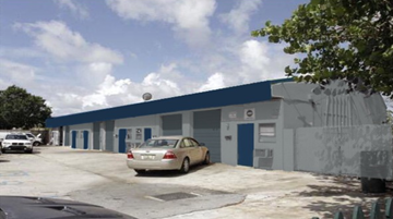 Pompano Beach apartment for rent - a car parked in front of a building with a blue roof