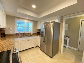 Bradenton house for rent - a kitchen with white cabinets and a stainless steel refrigerator