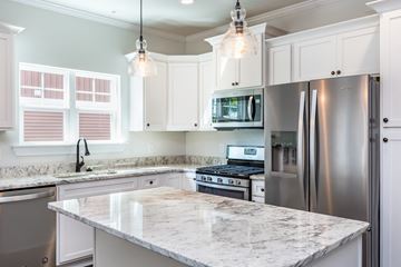 Spartanburg apartment for rent - a white kitchen with stainless steel appliances and marble counter tops