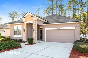 Jacksonville house for rent - a beige house with a driveway and a garage door