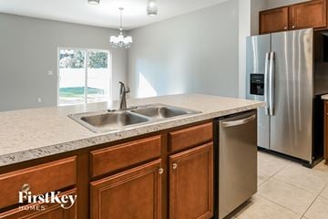 Jacksonville house for rent - a kitchen with a sink and a stainless steel refrigerator
