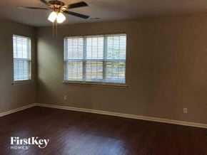 Charlotte house for rent - an empty living room with a ceiling fan and a window