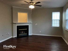 Charlotte house for rent - a living room with a fireplace and a ceiling fan