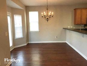 Charlotte house for rent - an empty living room with a chandelier and a kitchen