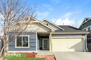 Denver house for rent - A house with a garage door and a tree in front of it.