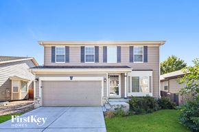 Parker house for rent - a beige house with a garage door and a driveway
