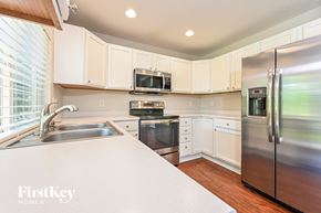 Parker house for rent - an updated kitchen with stainless steel appliances and white cabinets