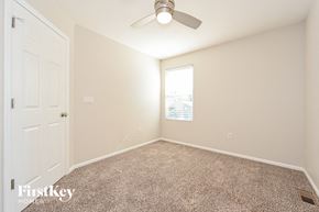 Parker house for rent - a bedroom with a ceiling fan and a white door