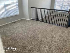 Commerce City house for rent - a carpeted room with a crib and a window