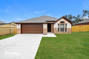 Dallas house for rent - a brick house with a garage and a driveway