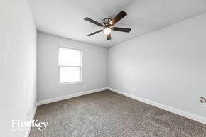 Dallas house for rent - a bedroom with white walls and a ceiling fan