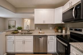 Largo apartment for rent - A modern kitchen with white cabinets and stainless steel appliances.