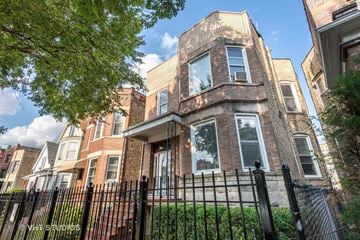 Chicago apartment for rent - a brick house with a fence in front of it