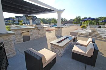 Poolside pavilion with fire pit, outdoor appliances, and 46 inch flat-screen tv