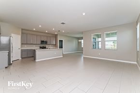 Riverview house for rent - an open kitchen and living room with white tile flooring and stainless steel appliances