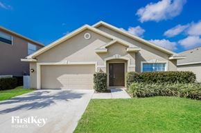 Fort Myers house for rent - a beige house with a garage door and a lawn
