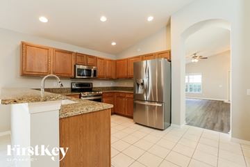 Fort Myers house for rent - a kitchen with wooden cabinets and a stainless steel refrigerator