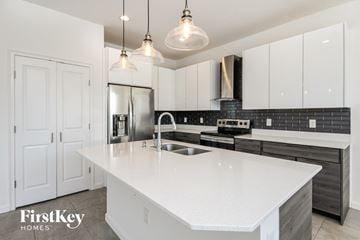 Davenport house for rent - a white kitchen with white counter tops and black and white cabinets