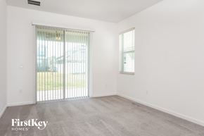 Davenport house for rent - the living room of an apartment with a large window and a door to the yard