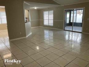 Jacksonville house for rent - A spacious room with tile flooring and a sliding glass door.