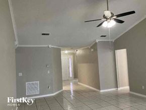 Jacksonville house for rent - A spacious room with a ceiling fan and tiled flooring.
