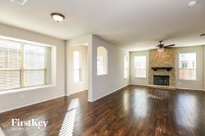 Fort Worth house for rent - an empty living room with a fireplace and wooden floors