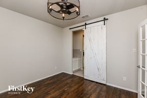 Fort Worth house for rent - a bedroom with a sliding barn door and a bathroom