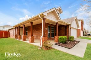 Crossroads house for rent - a brick house with a porch and a lawn
