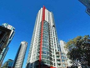 Vancouver apartment for rent - A tall building with a red stripe on the side stands out against the sky.
