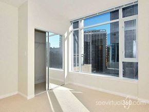 Vancouver apartment for rent - A room with a white wall and a glass door leading to a balcony.