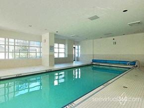 Vancouver apartment for rent - A large indoor swimming pool with a bench and windows.