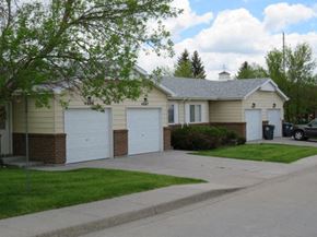 Cheyenne townhouse for rent - a white house with two garages and a driveway