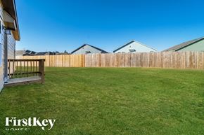 Bulverde house for rent - A backyard with a wooden fence and a grassy area.