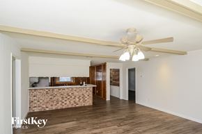 Spring house for rent - A spacious room with a ceiling fan and a brick wall.